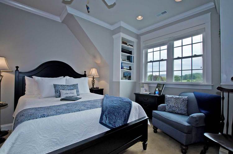 view of bedroom featuring queen bed and seating area with blue arm chair