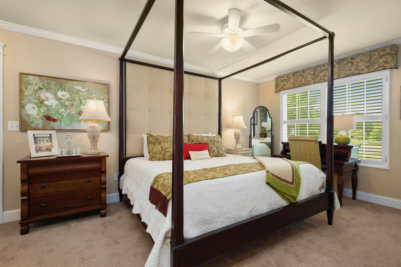Canopy bedroom with ceiling fan, desk, and large window