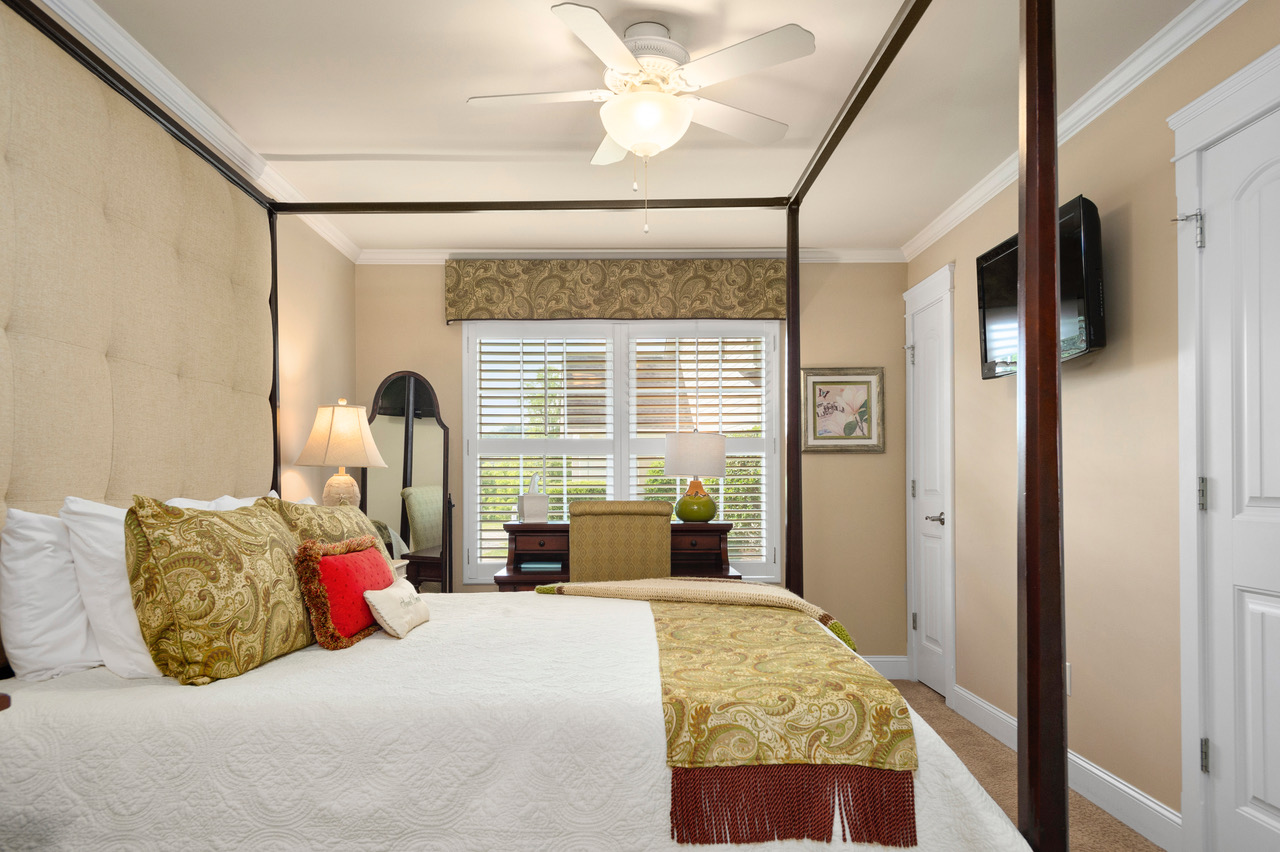 queen bed with green pillows and throw