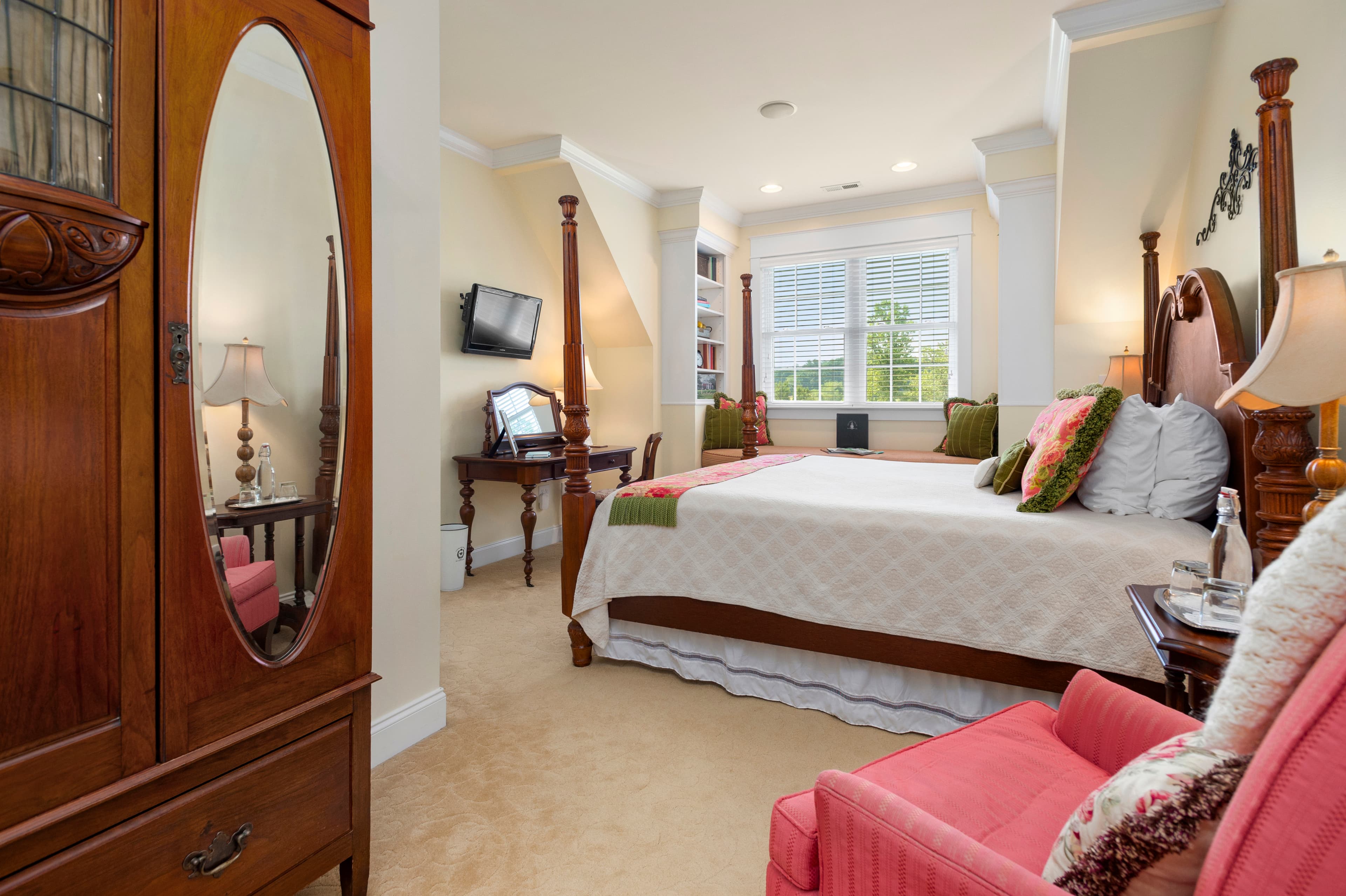 bedroom featuring King bed, pink armchair, and large window