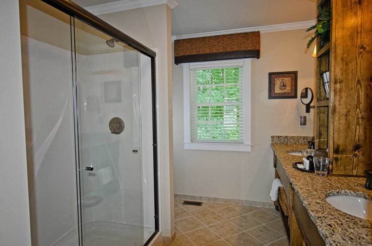 bathroom featuring walk-in shower and double-vanity
