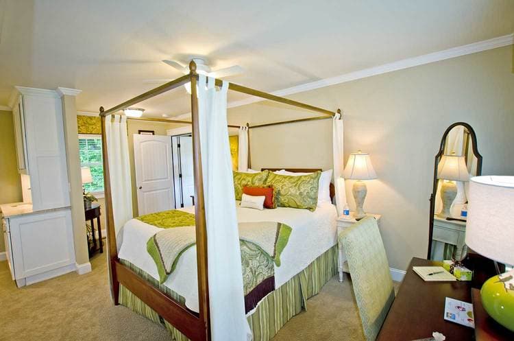 queen bed with green pillows and throw