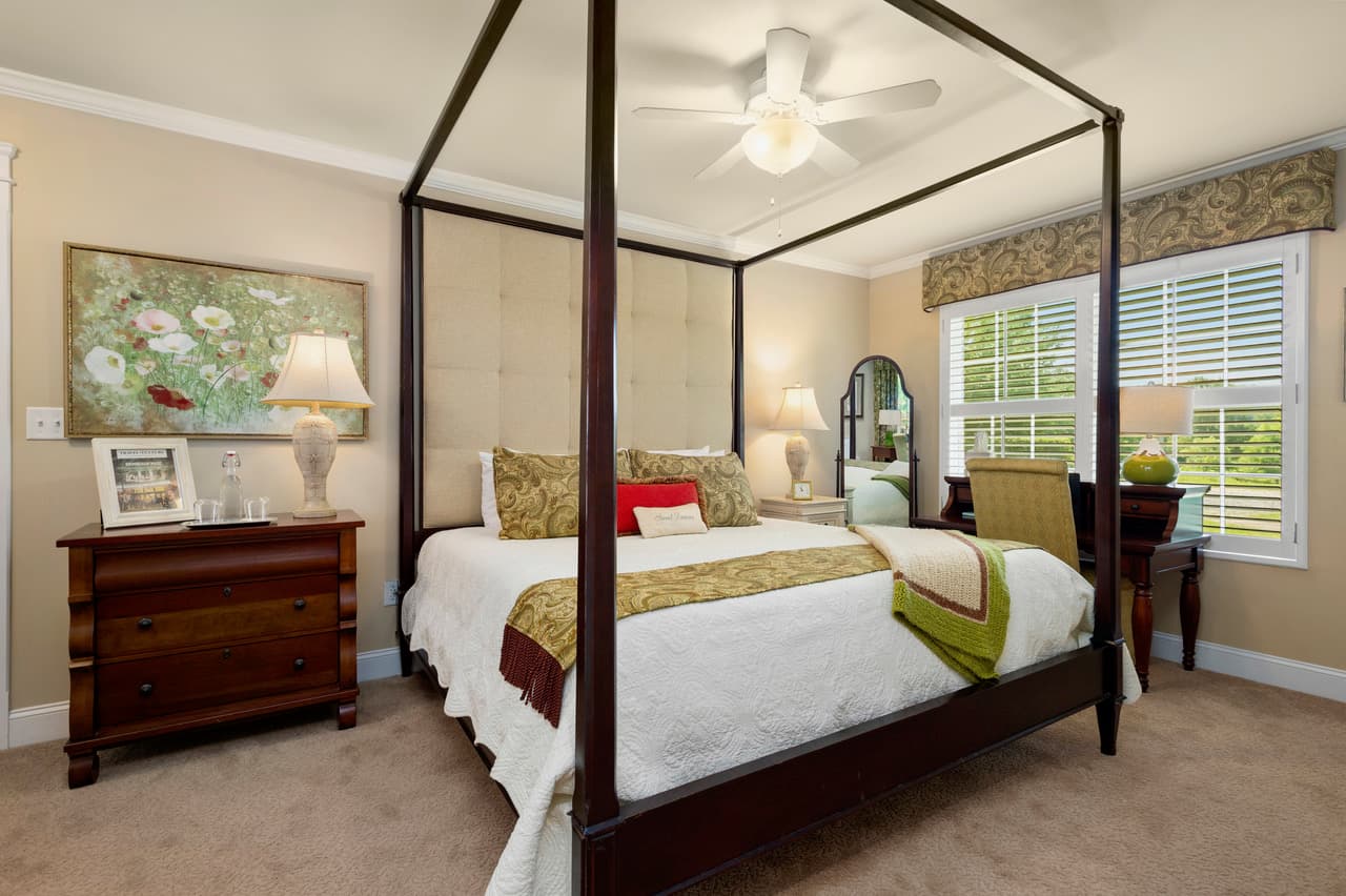 Canopy bedroom with ceiling fan, desk, and large window