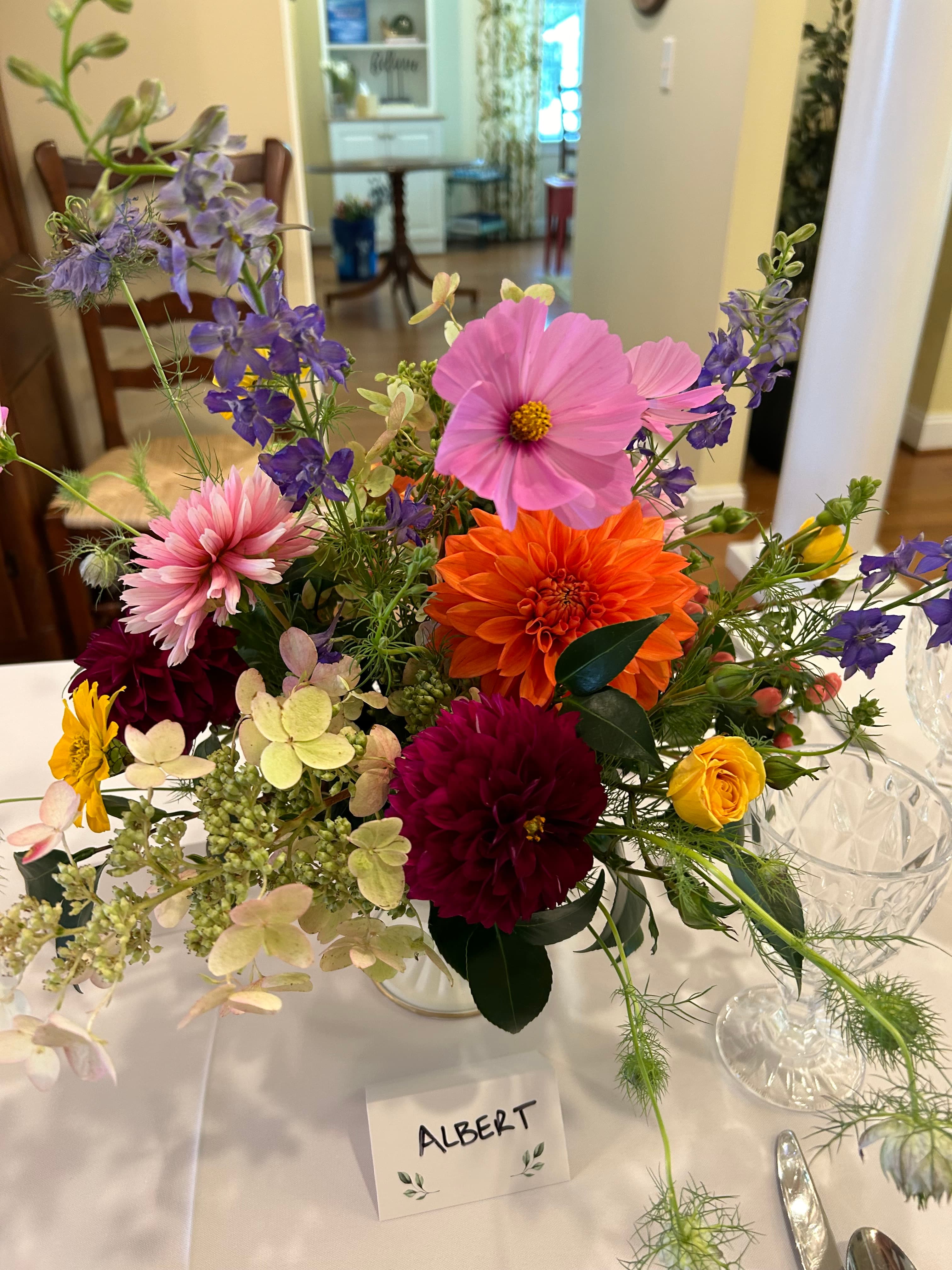 A colorful floral arrangement with a name tag reading "ALBERT" on a table.