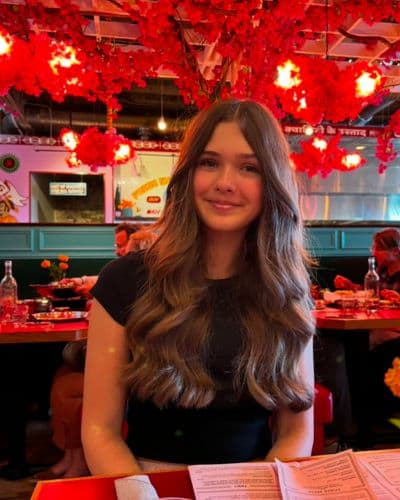 Girl with long brown hair sitting at a table in a restaurant