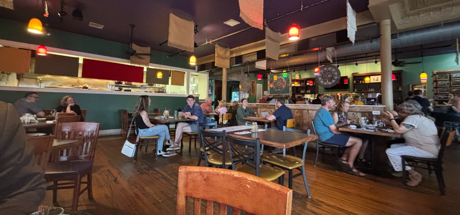 Interior of a restaurant with eclectic decor and people sitting at tables